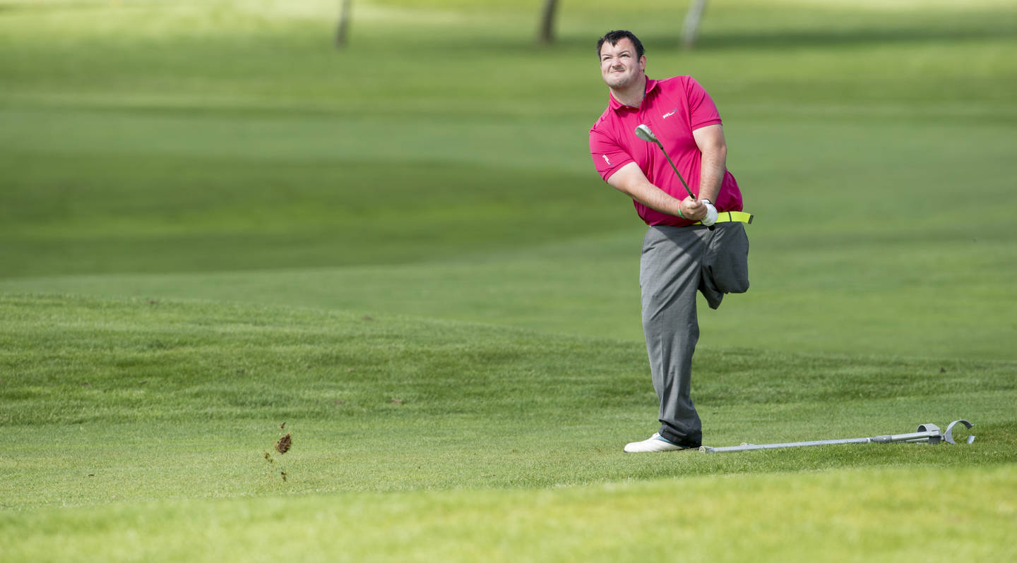 A man, who is a leg amputee, playing golf