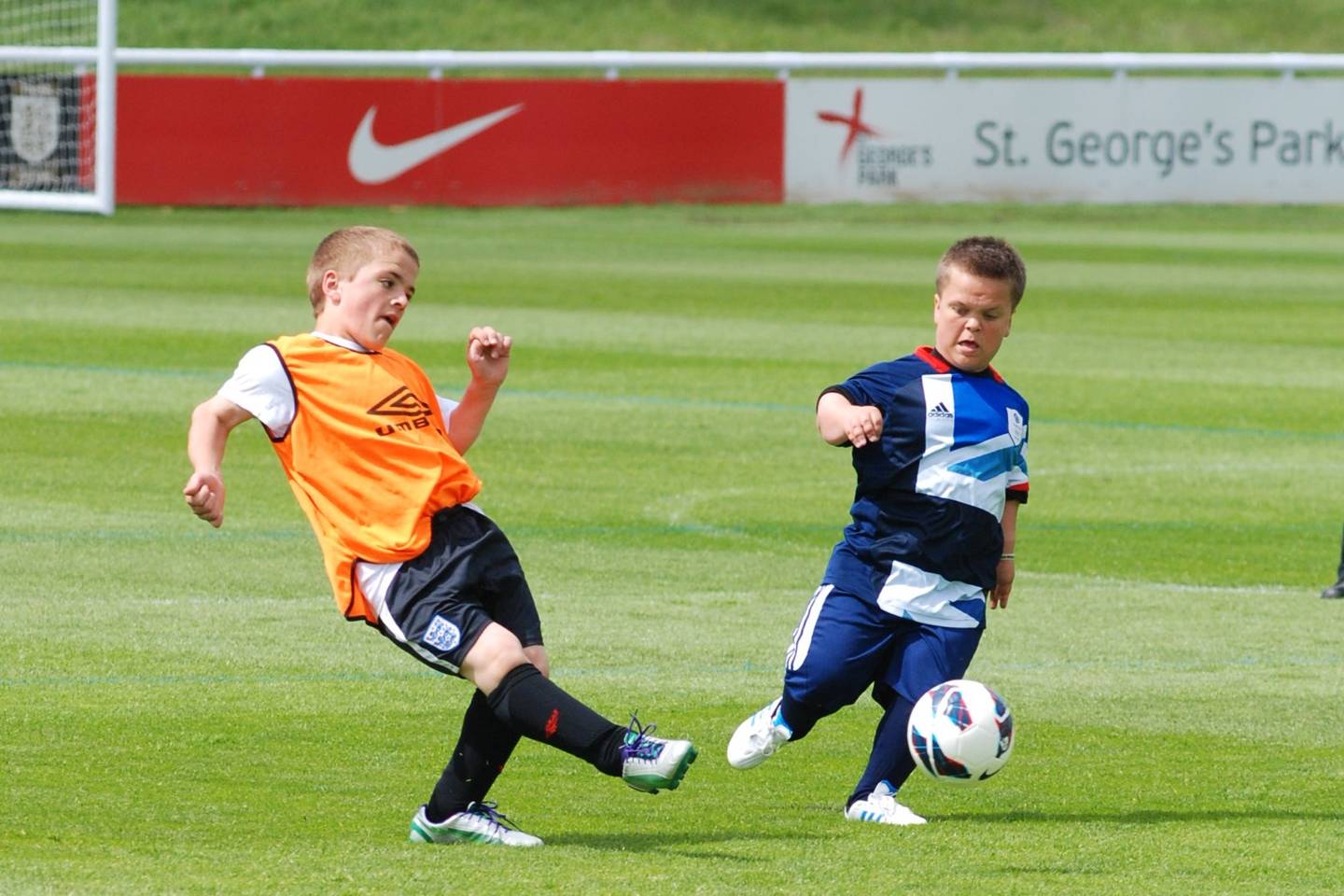 Two people with dwarfism playing football