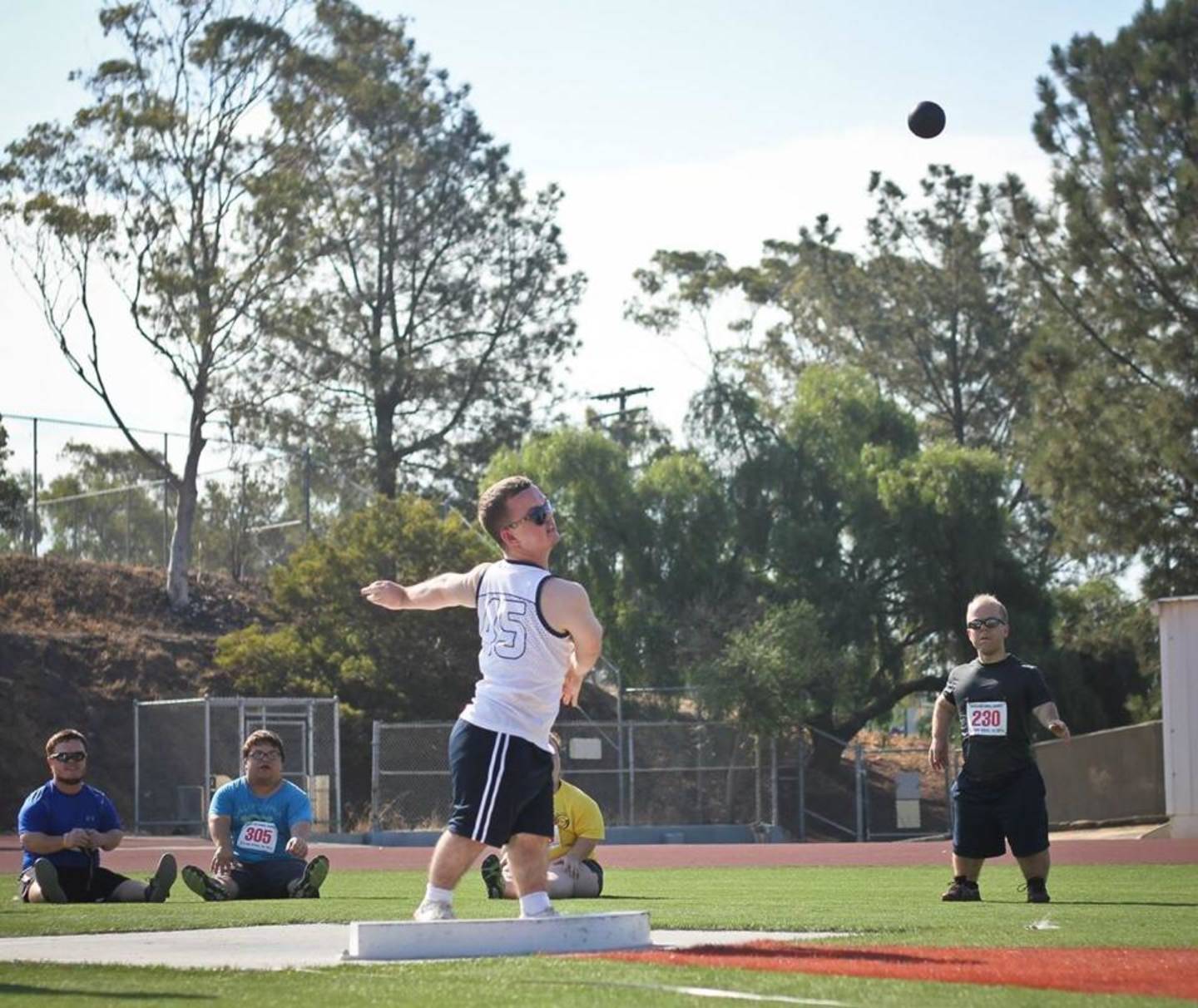 Man with dwarfism throwing shot put