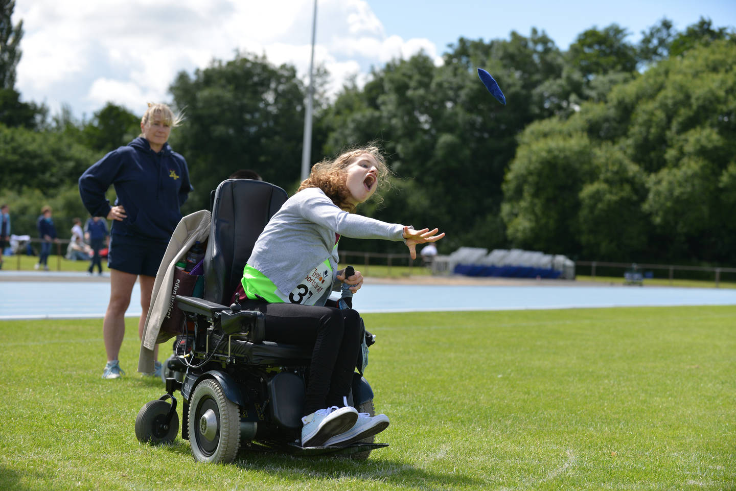 A young woman powerchair user throwing a bean bag