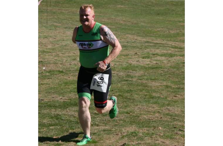 Image shows Danny Green running in triathlon race. 