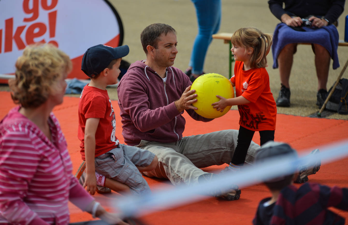 Family playing sitting volleyball