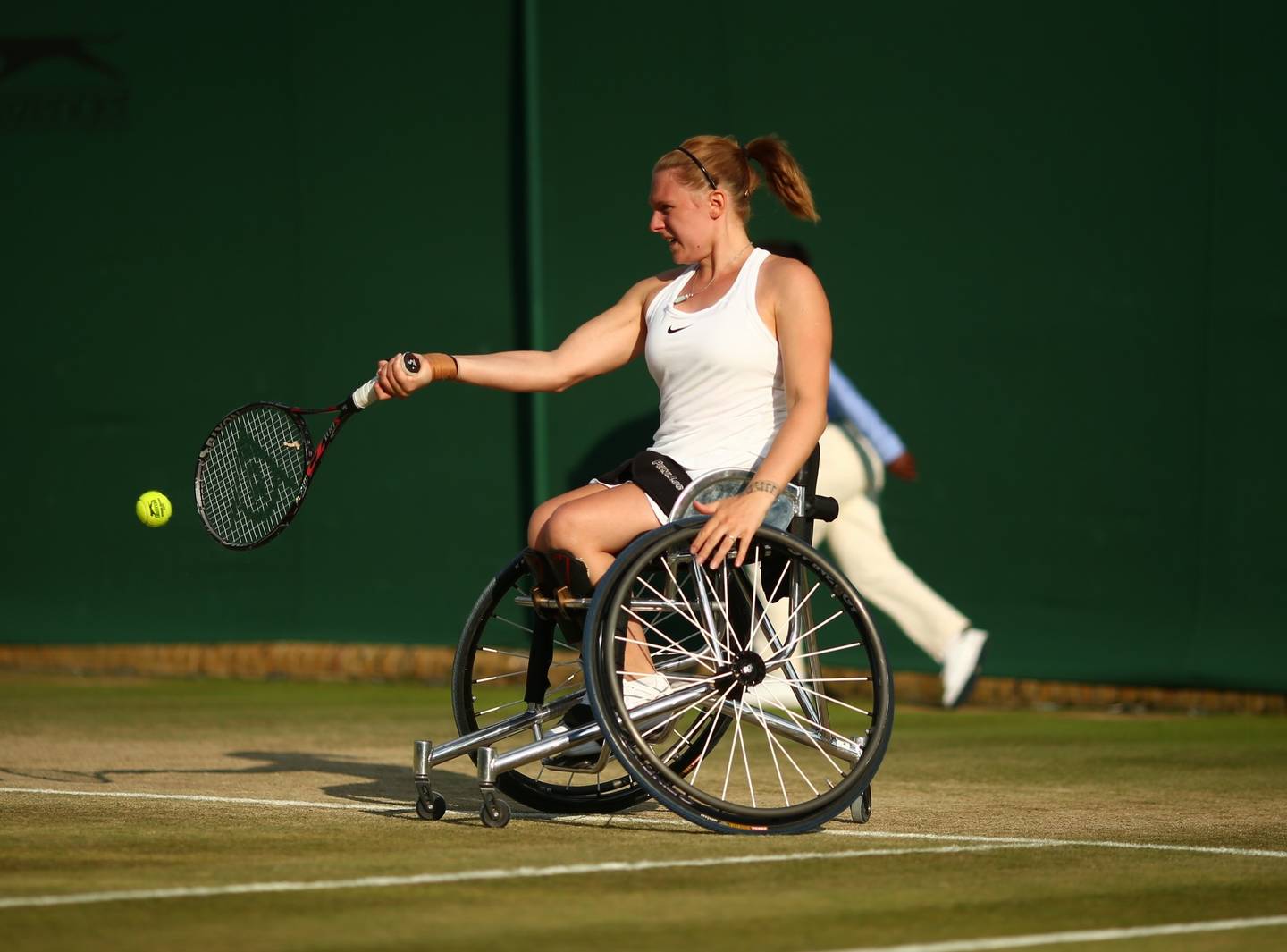 Jordanne Whiley, wheelchair tennis player hitting forehand on grass court