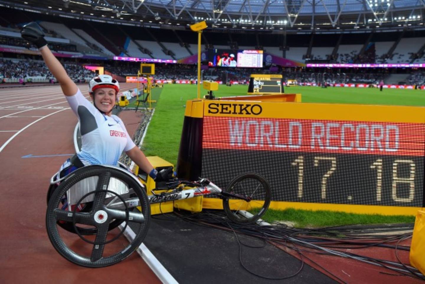 Wheelchair racer celebrating new world record infront of time board