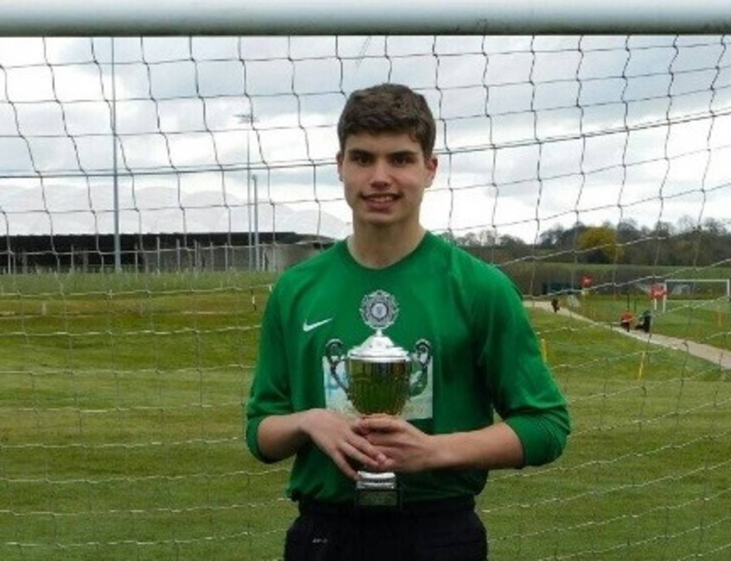 Ben Meadows in front of the net with a trophy