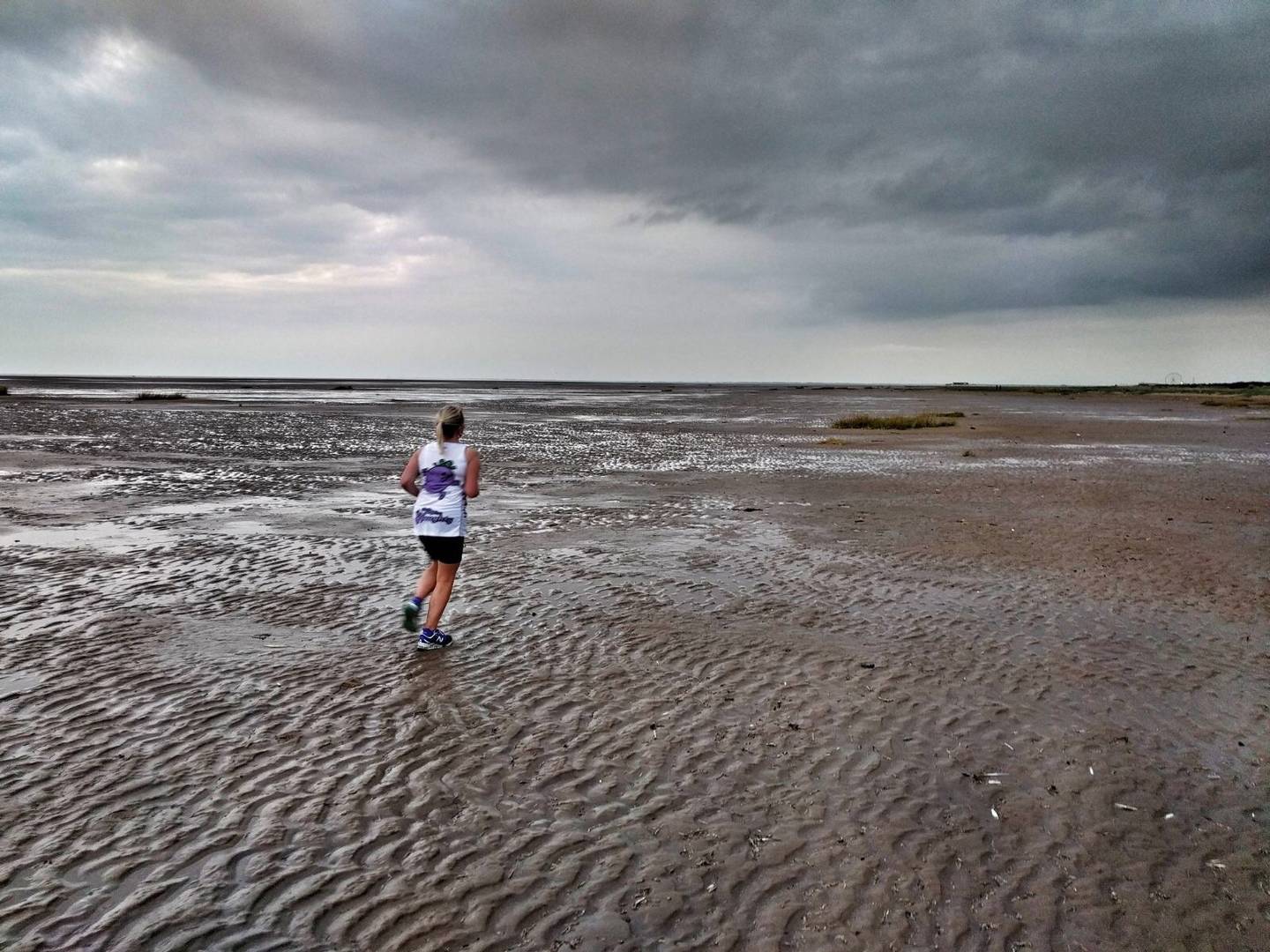 Kelly Barton running on the beach without a guide
