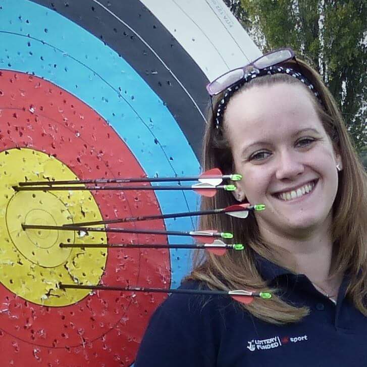 Lauren Sanders standing next to archery target