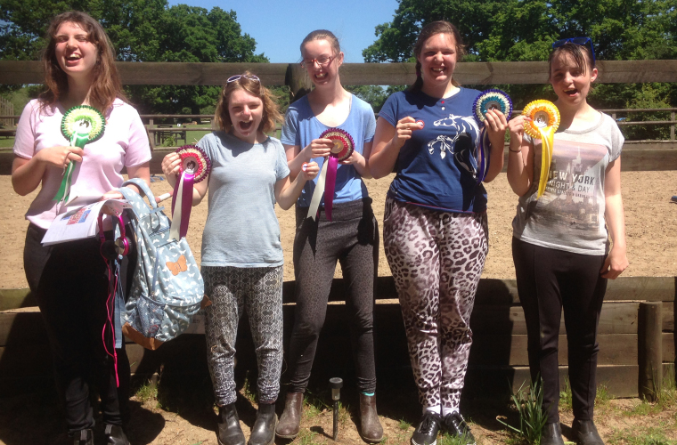 Riding students celebrating with their rosettes