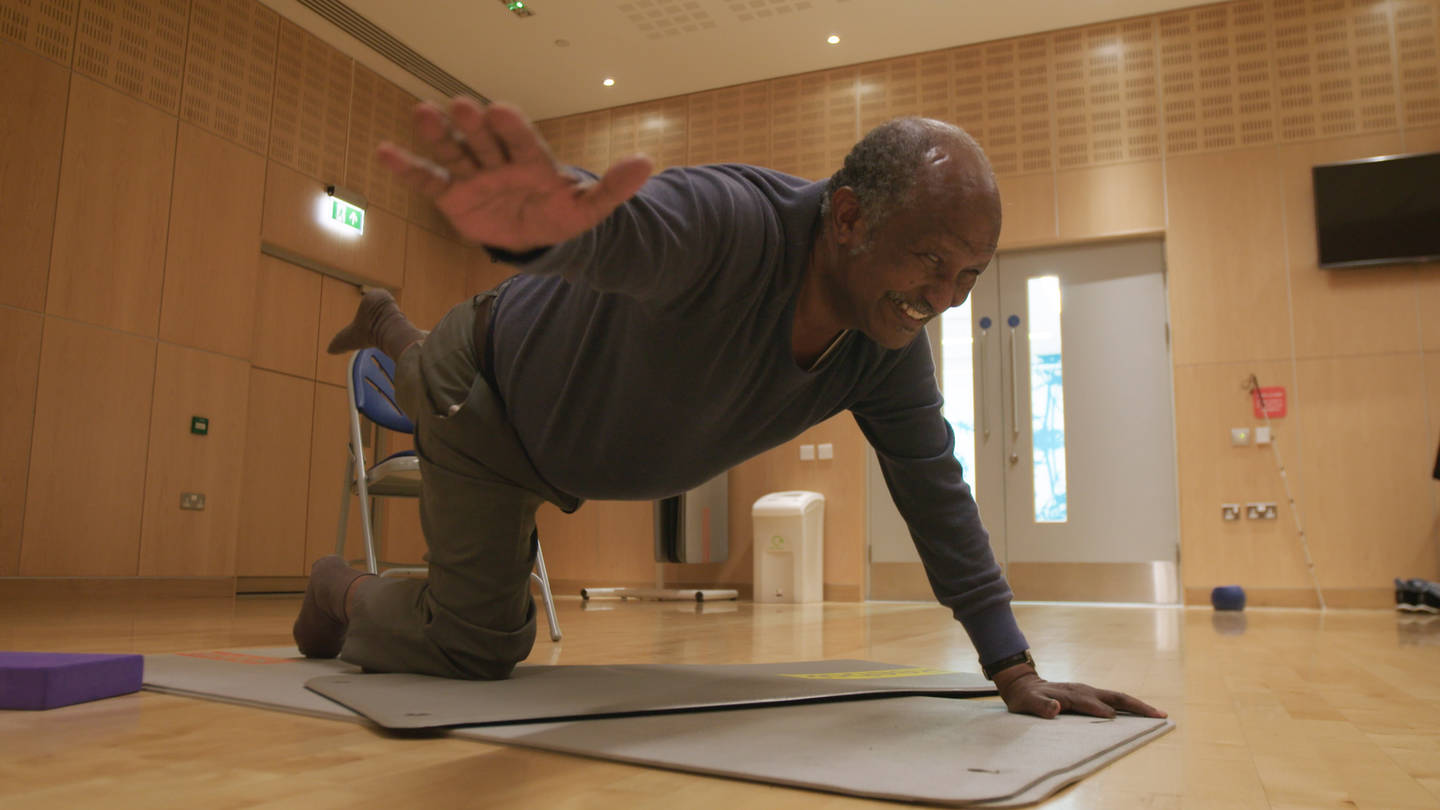 Tesfai taking part in group yoga class for deafblind people