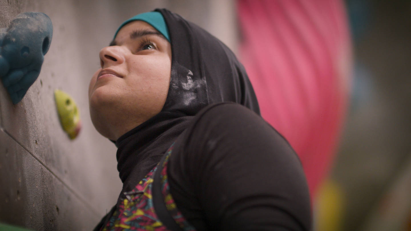 Anoushe looking up at climbing wall