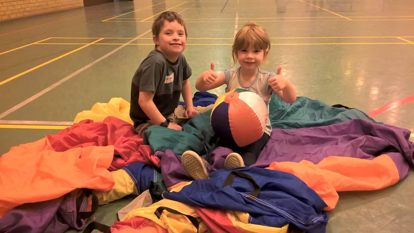 Young children playing together in sports hall 