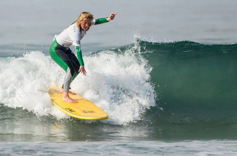 Team England Surfer Charlotte Banfield surfing on her yellow board. 