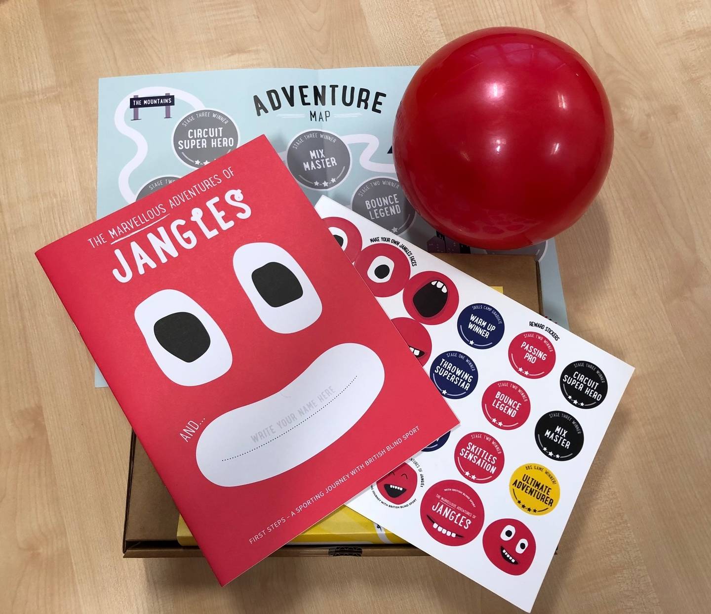 Photo shows contents of First Steps pack with jingle ball and activity book
