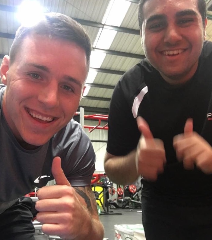 Sami with Ben in the gym, thumbs up to camera 