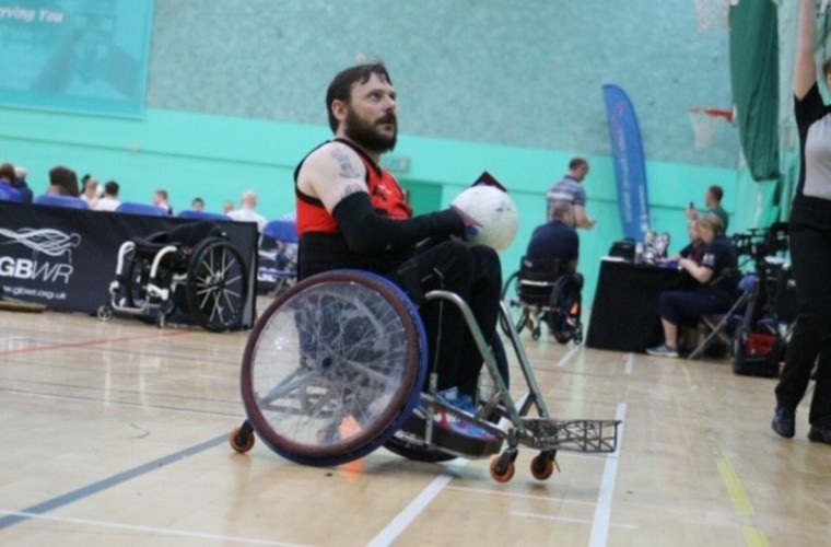 Ryan on court with rugby ball in hand. 