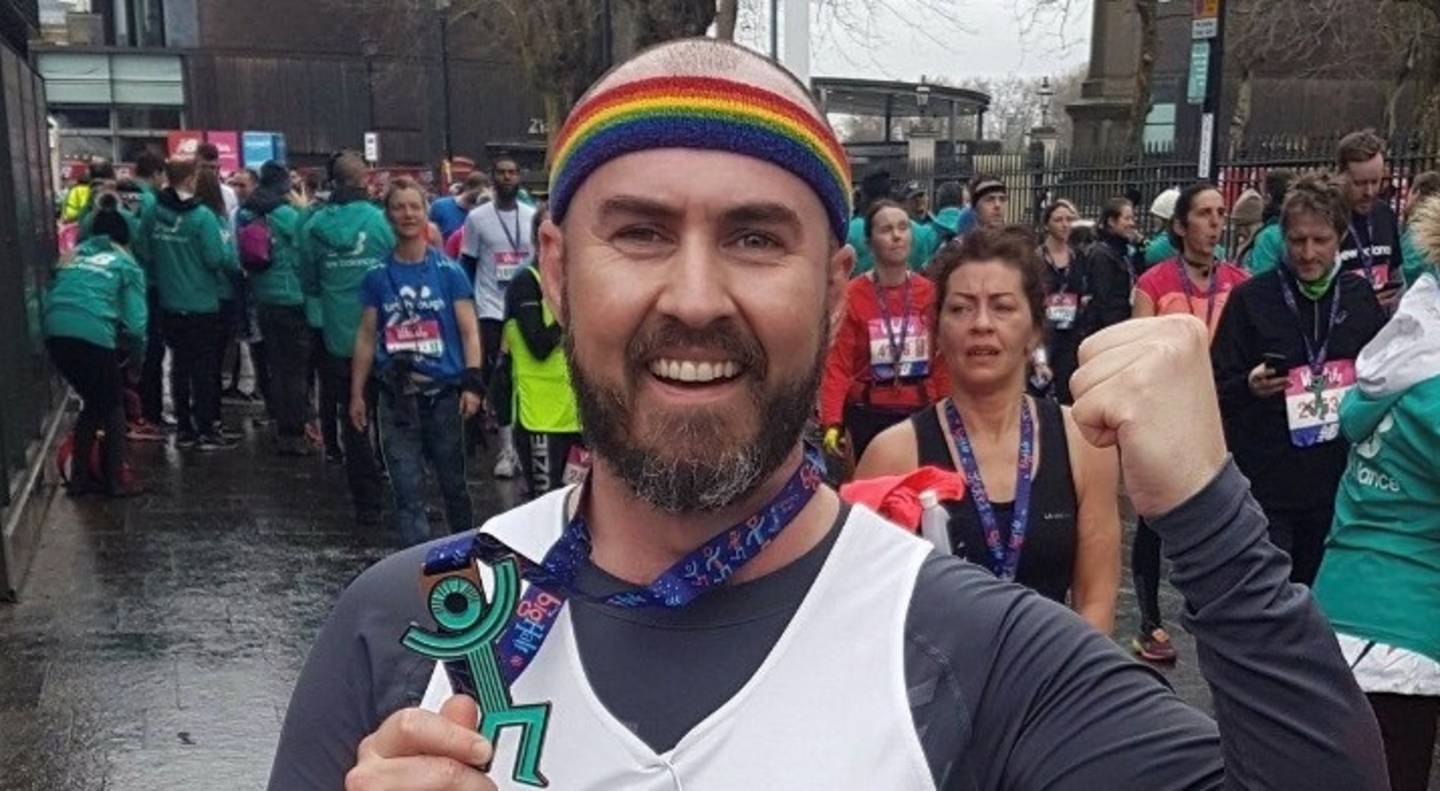 Martin Doyle smiling with medal in hand after Vitality Big Half run in 2018