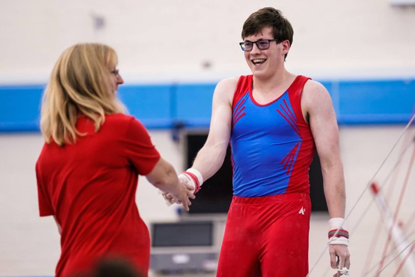 Male disabled gymnast smiling and giving his coach a high five