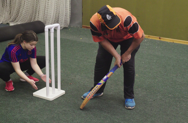 Visually impaired batter and wicket keeper waiting for cricket ball delivery