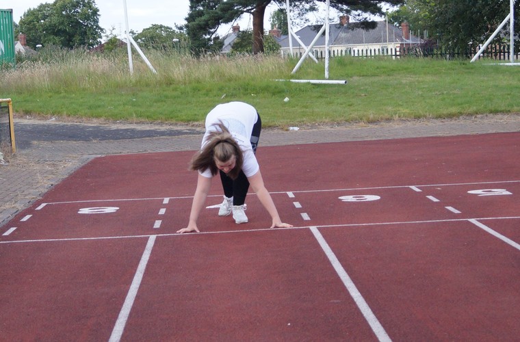 Ellie in start position on running track. 