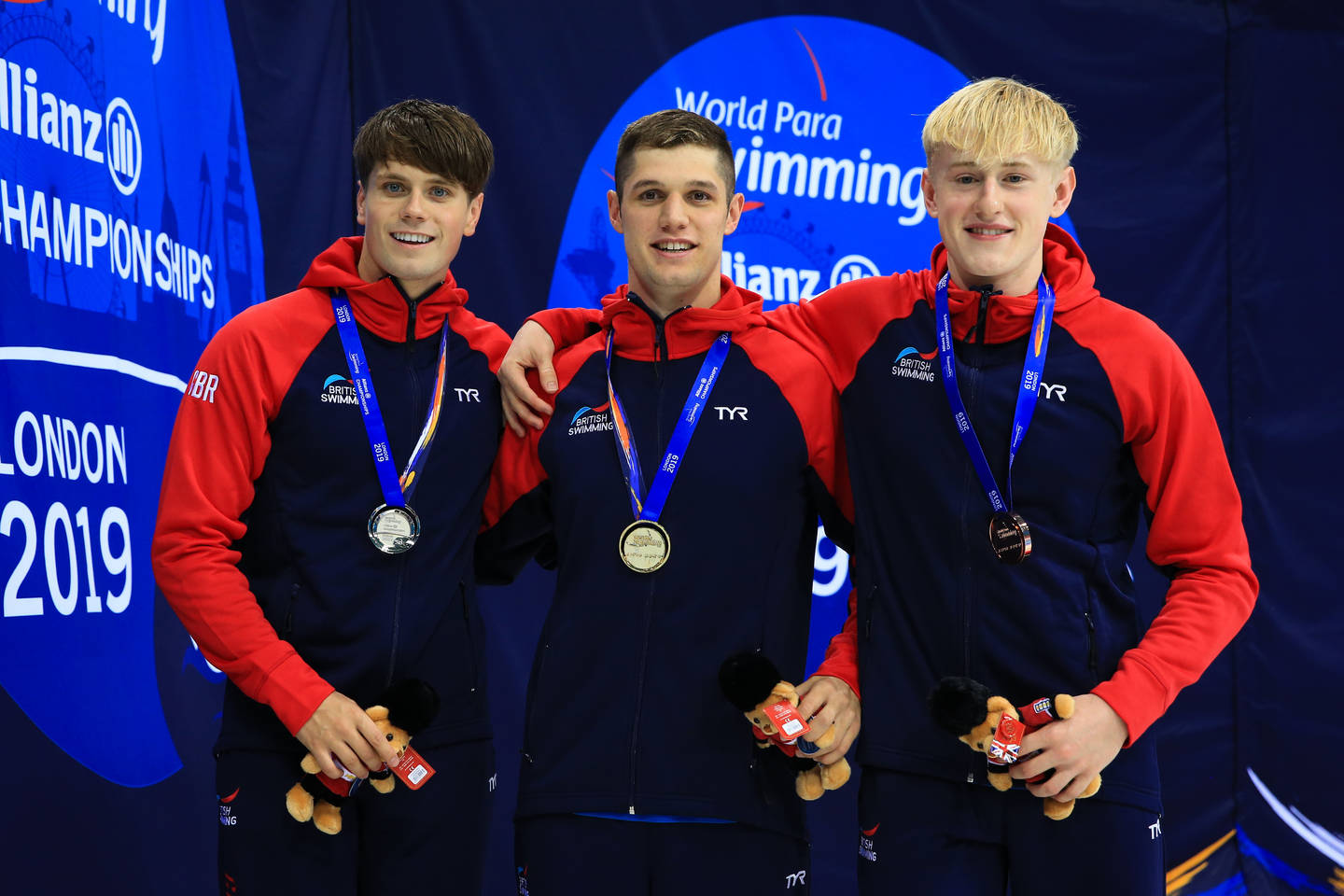 Reece Dunn, Tom Hamer and Jordan Catchpole wear medals on the podium 