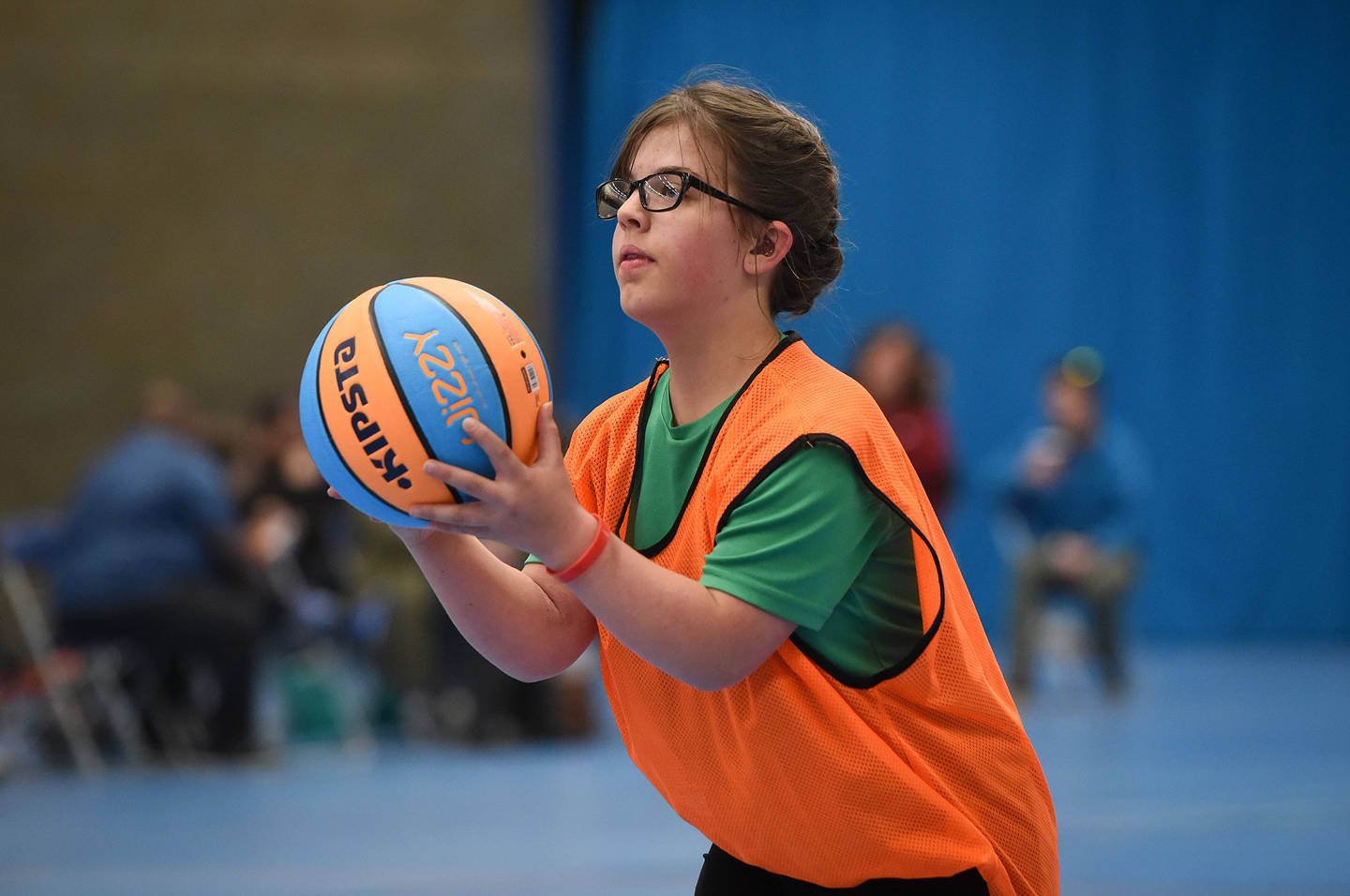 Young woman with dwarfism and hearing impairment playing basketball 