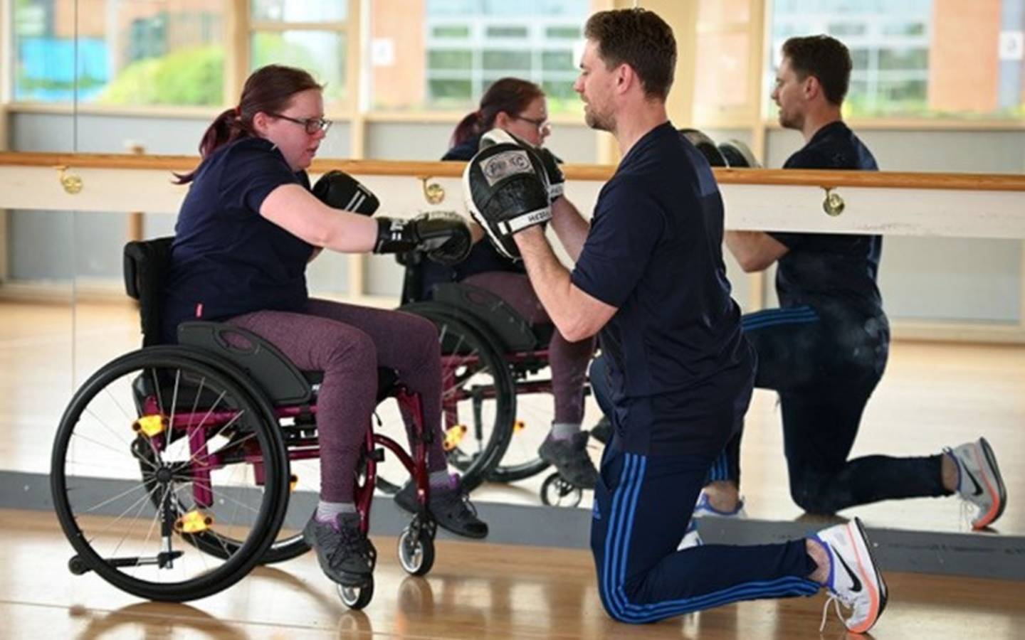 Woman in wheelchair taking part in adapted boxing session