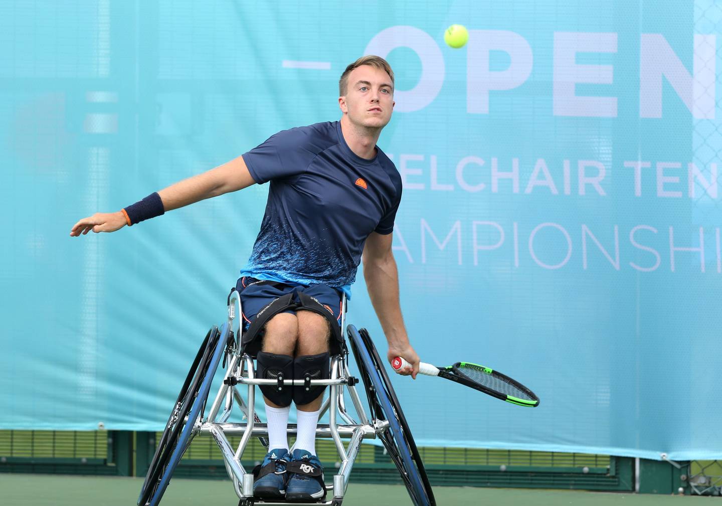 Dermot Bailey hitting a forehand shot on tennis court