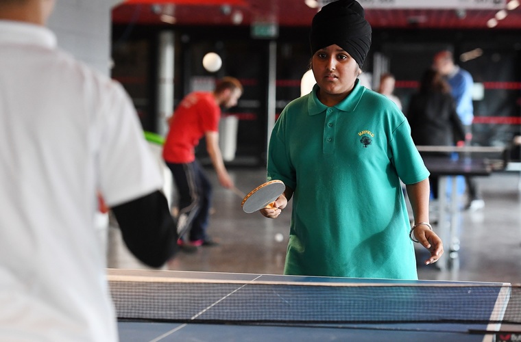 Boy playing table tennis at school event
