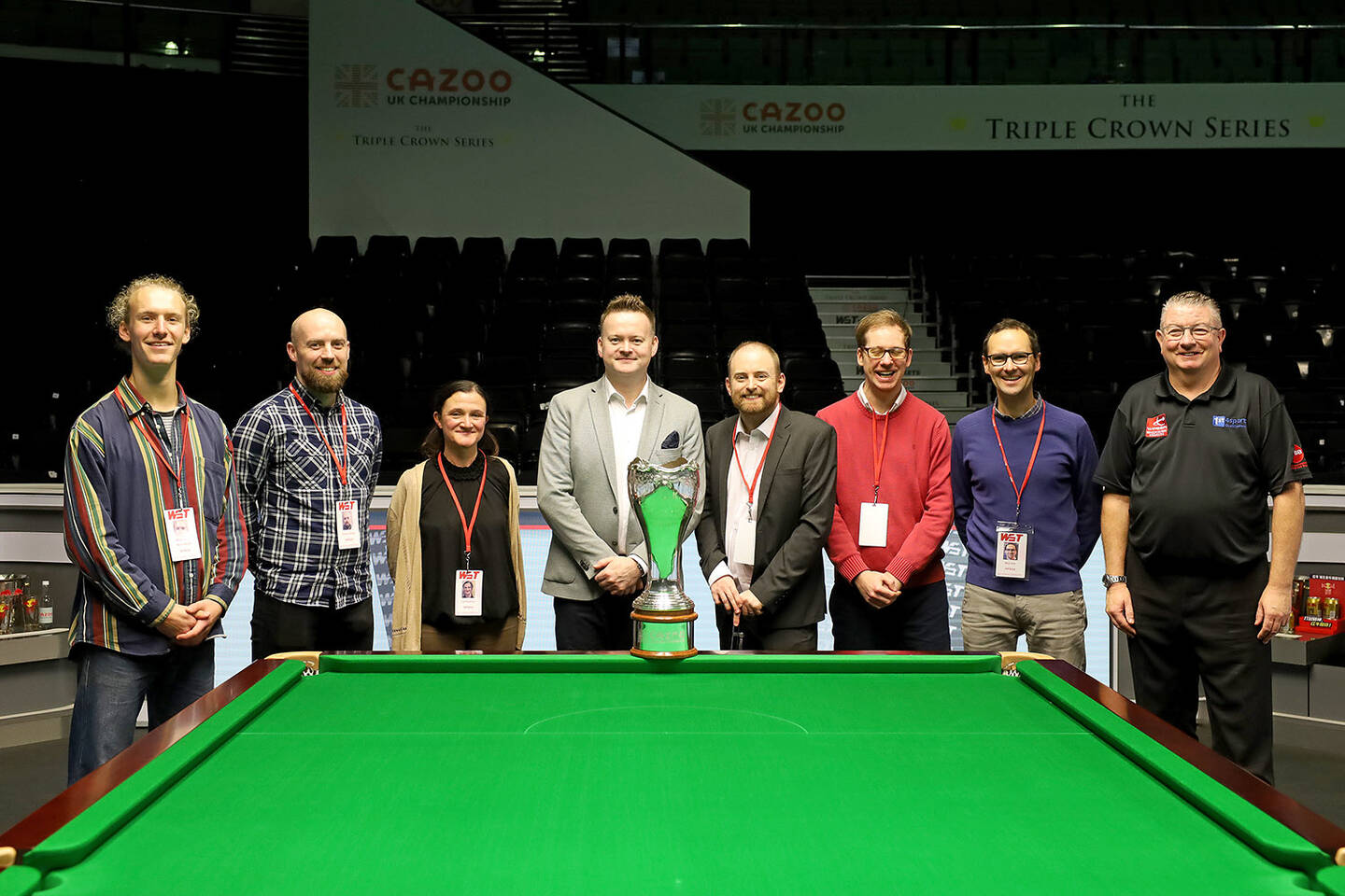 Group of people representing the new guide smiling around a snooker table