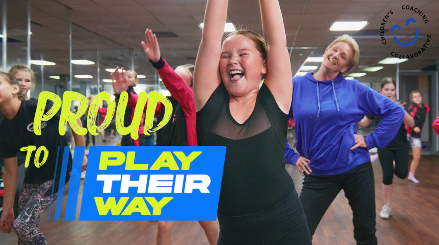 A girl holding her hands up smiling in front of a group doing exercise. The words Proud to Play Their Way are over the image.