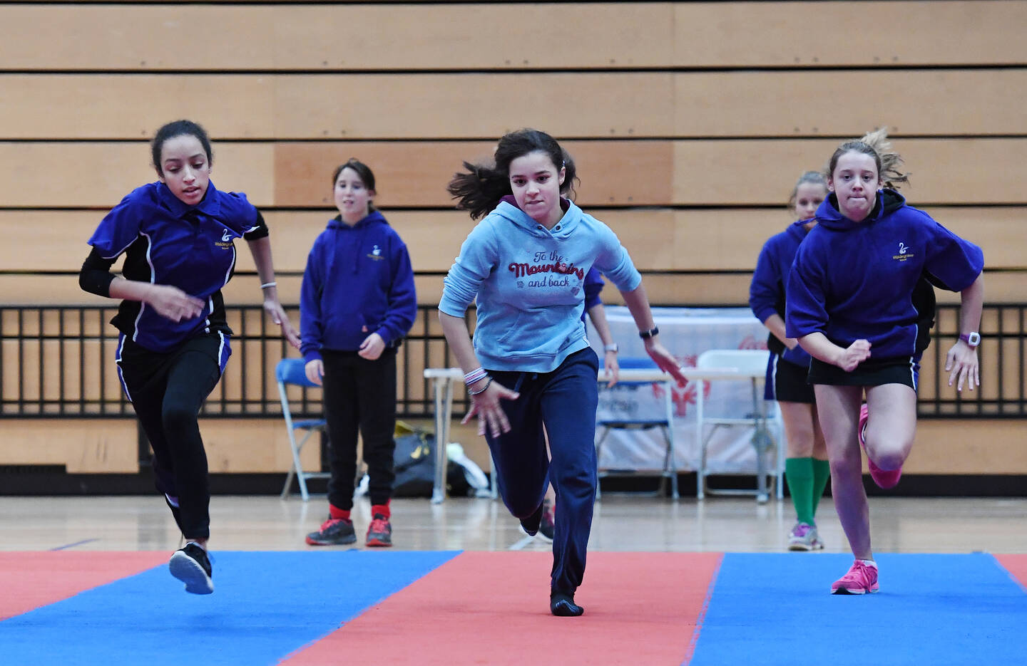 Teenage girls taking part in a sprint race during a PE session.