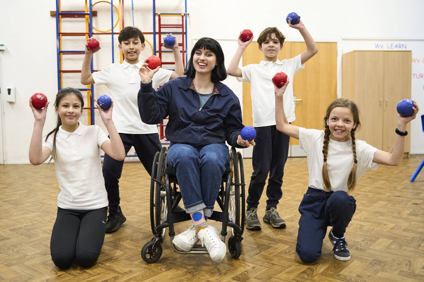 BBC presenter Abby Cook with school children holding boccia balls