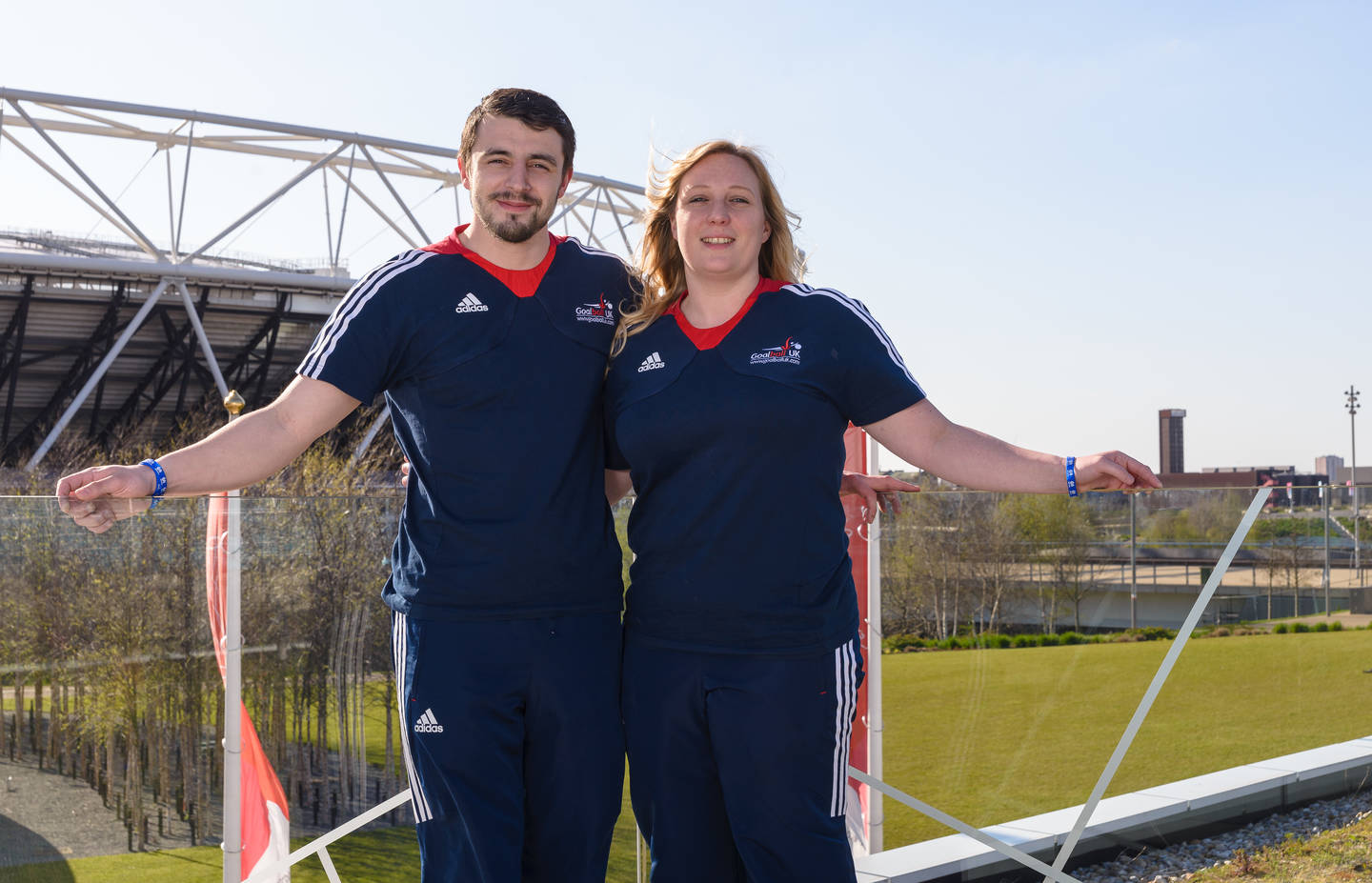 Dan Roper and Laura Perry standing together by a sports court