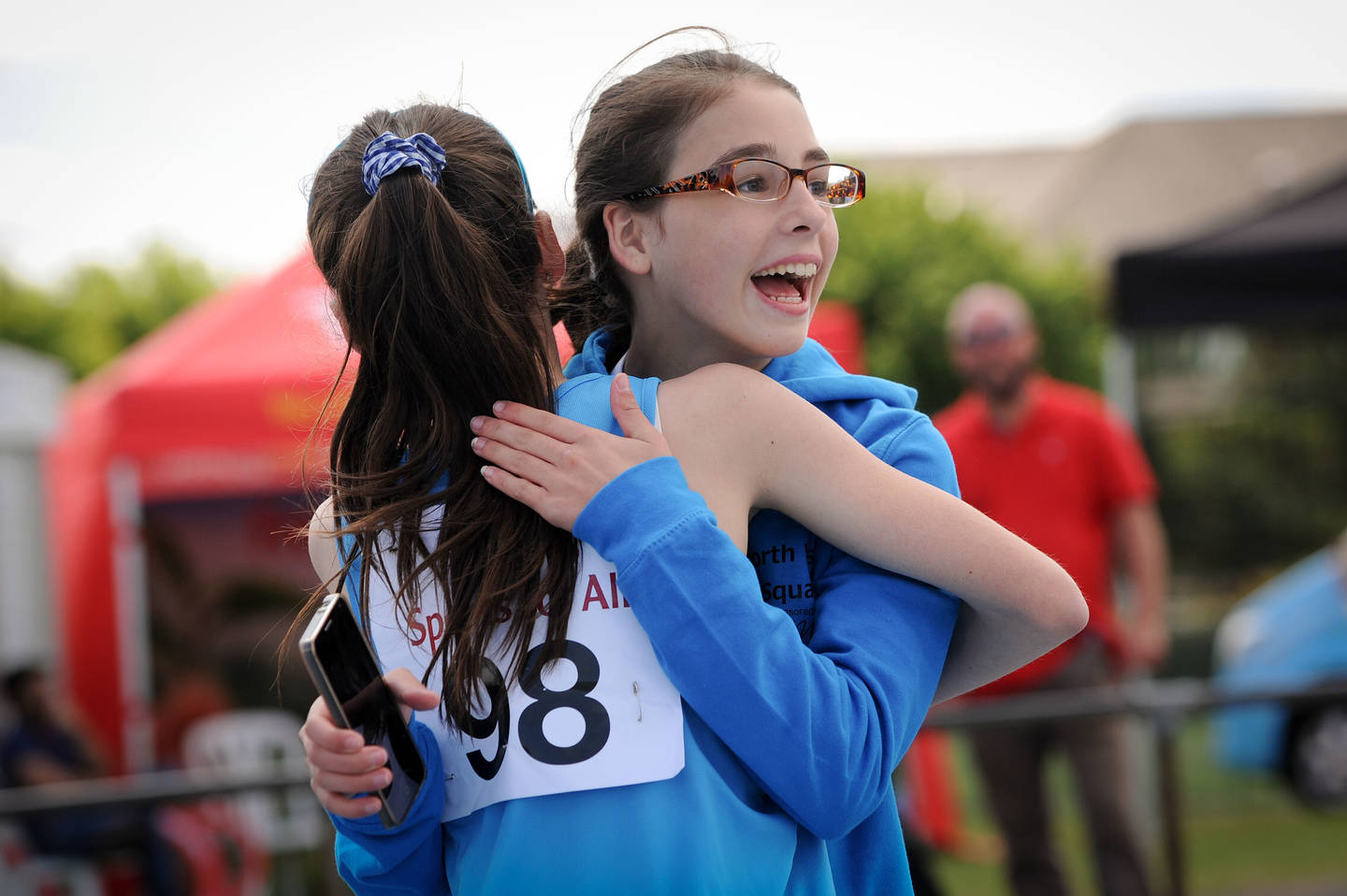 Two girl athletes hug after a race