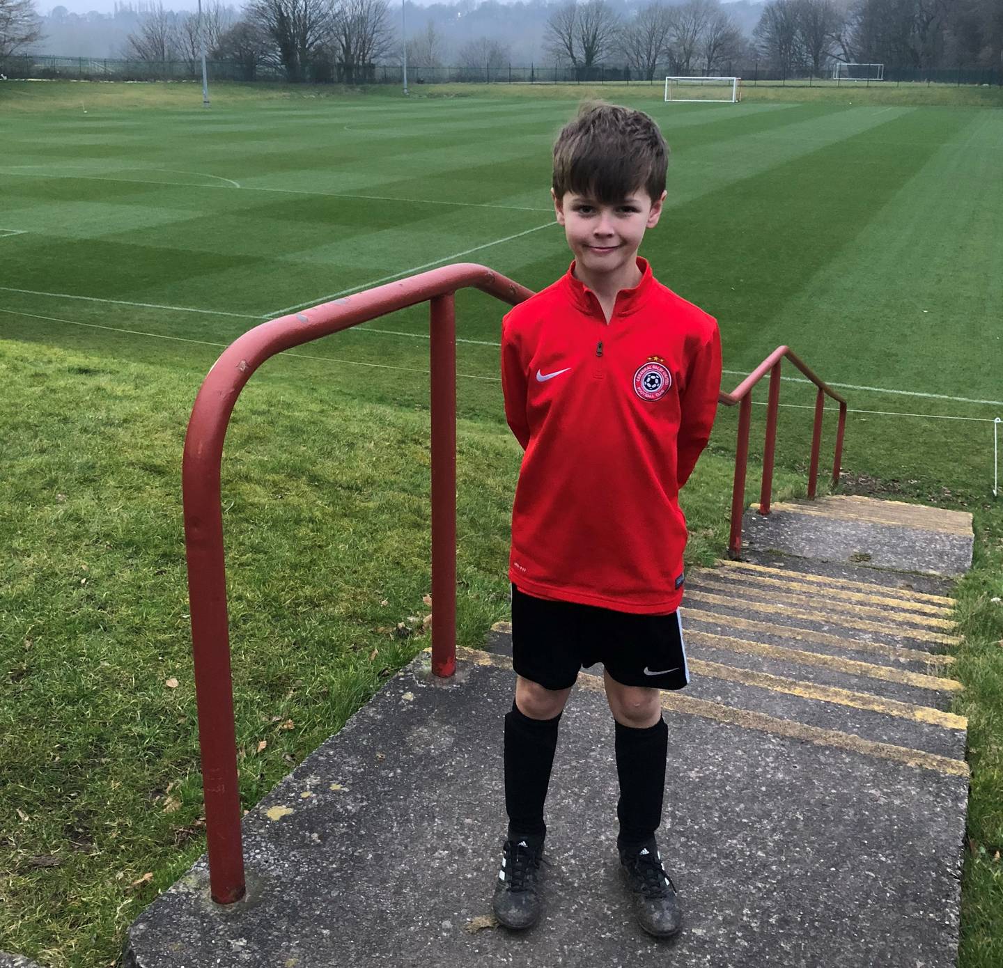 Bryan smiling to camera in his CP United football kit. 