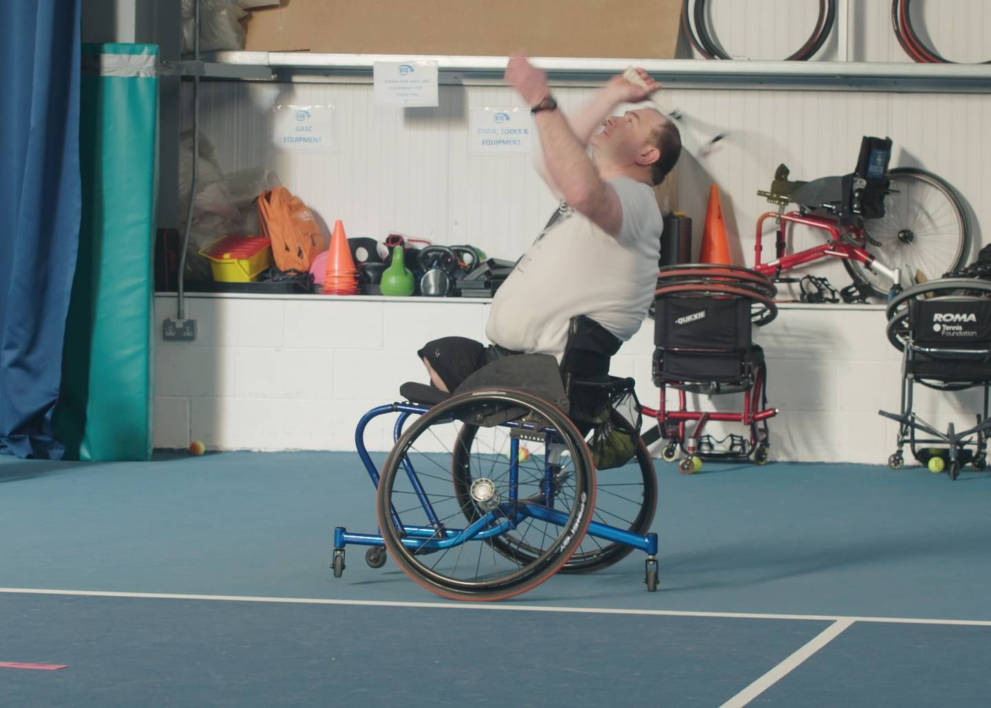 Wheelchair tennis player Paul serves during a game