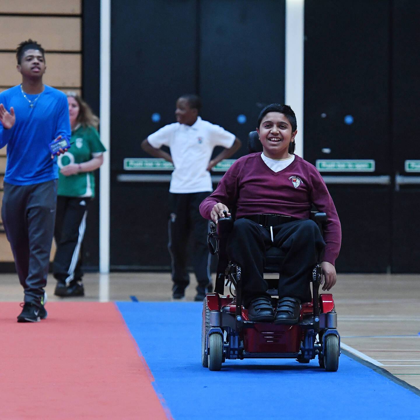 Boy in a powerchair having fun at school sports event