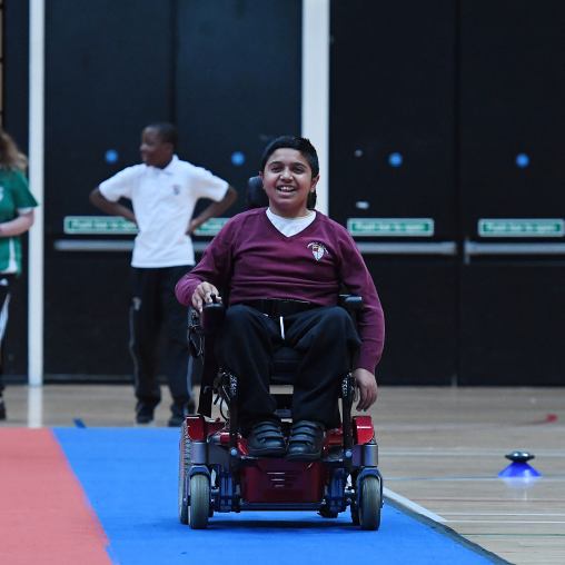 Boy in a powerchair having fun at school sports event