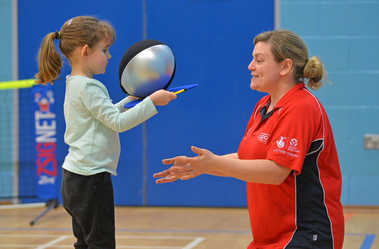 Young visually impaired girl playing adapted tennis game