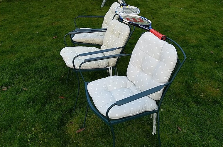 Garden chairs lined up on grass to act as a tennis net