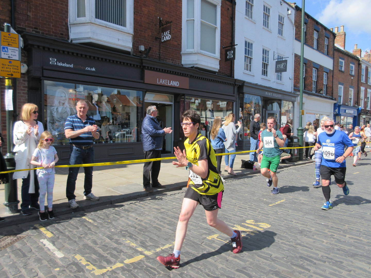 Nicola taking part in a running event with crowds cheering her on.