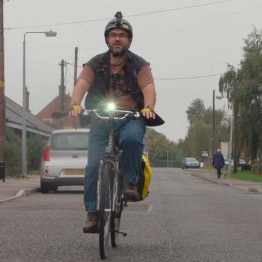 Disabled man cycling his bike down a residential road