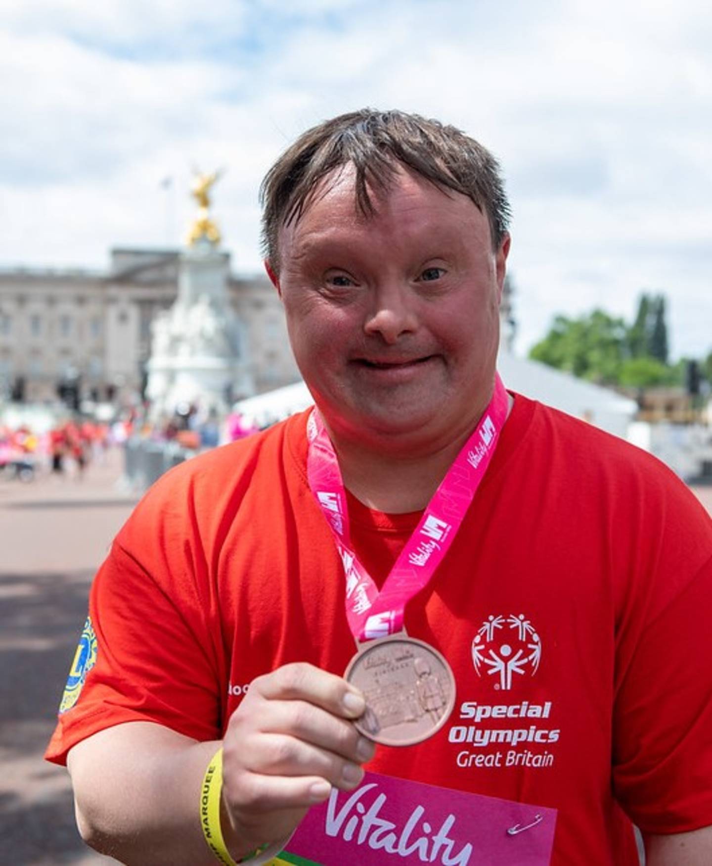 Greg smiling to camera with a Vitality Big Half race medal around his neck. 