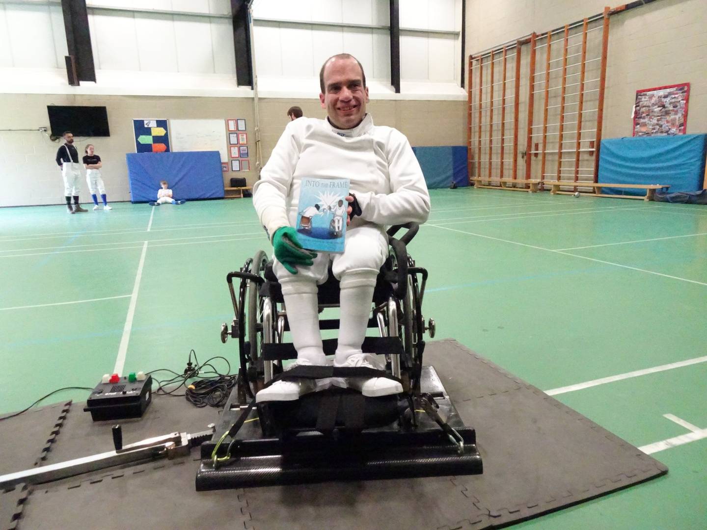 Jon in his fencing gear smiling to camera 