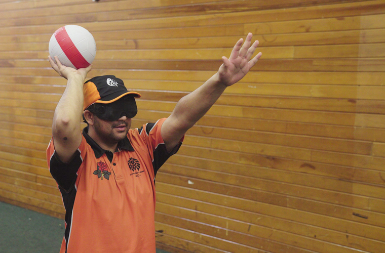 Visually impaired man bowling ball in a cricket game