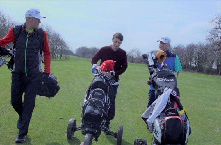 Disabled man with upper limb impairments playing round of golf with friends