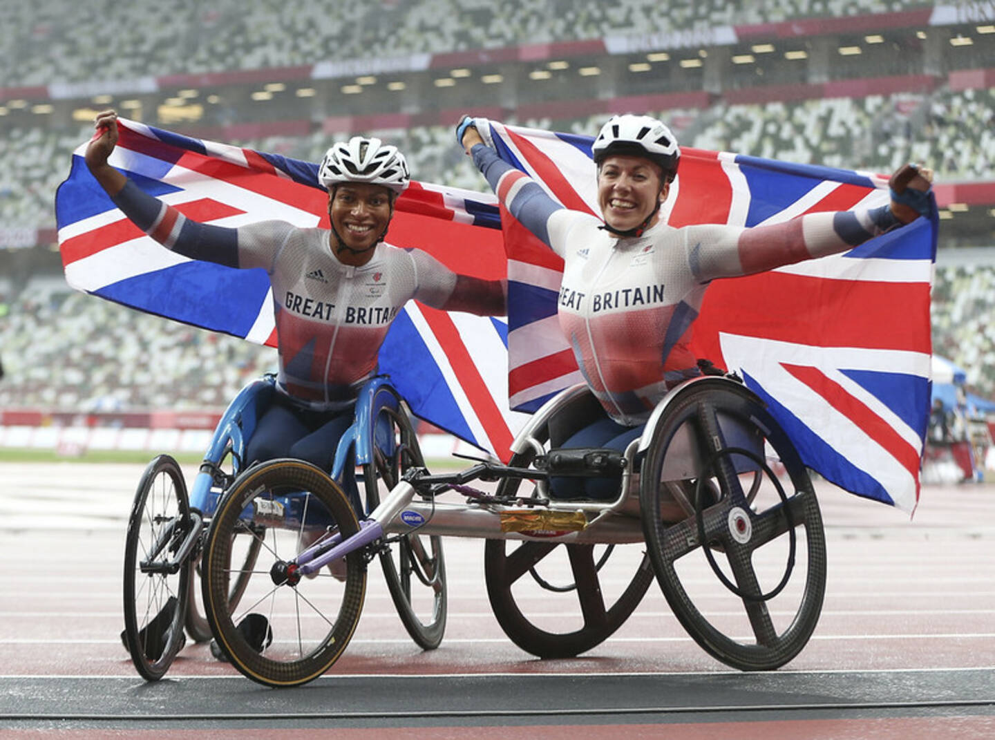 Hannah Cockroft and Kare Adenegen hold GB flags after winning gold and silver in 800m T34 at Tokyo 2020