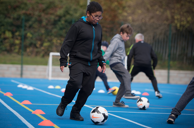 Boy with a visual impairment playing football. Photo credit: British Blind Sport