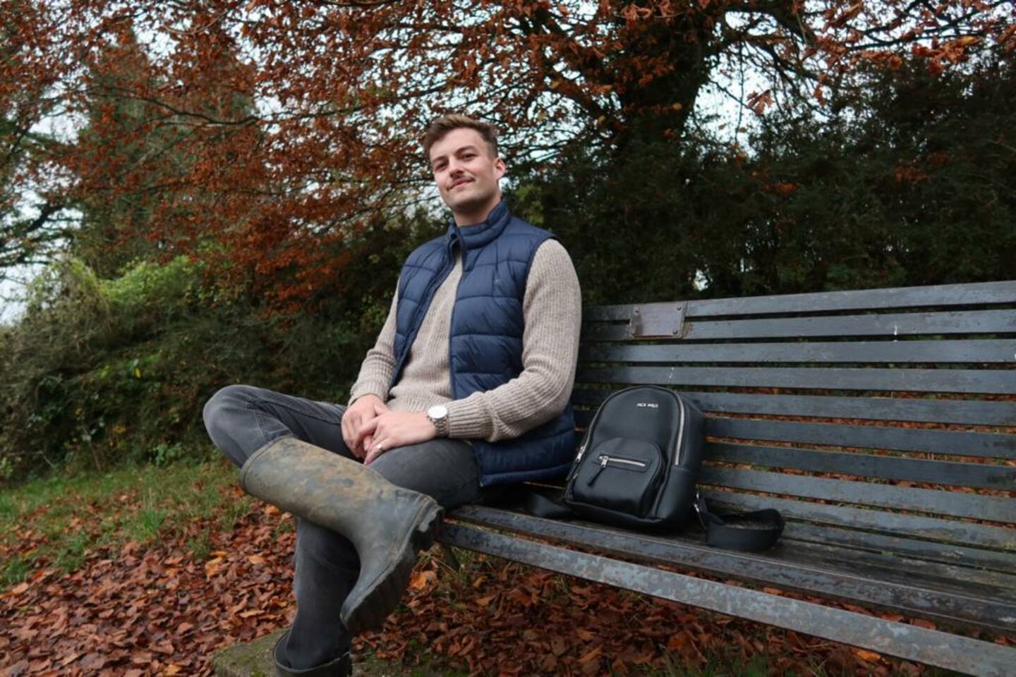 Hugo on a park bench smiling to camera. 