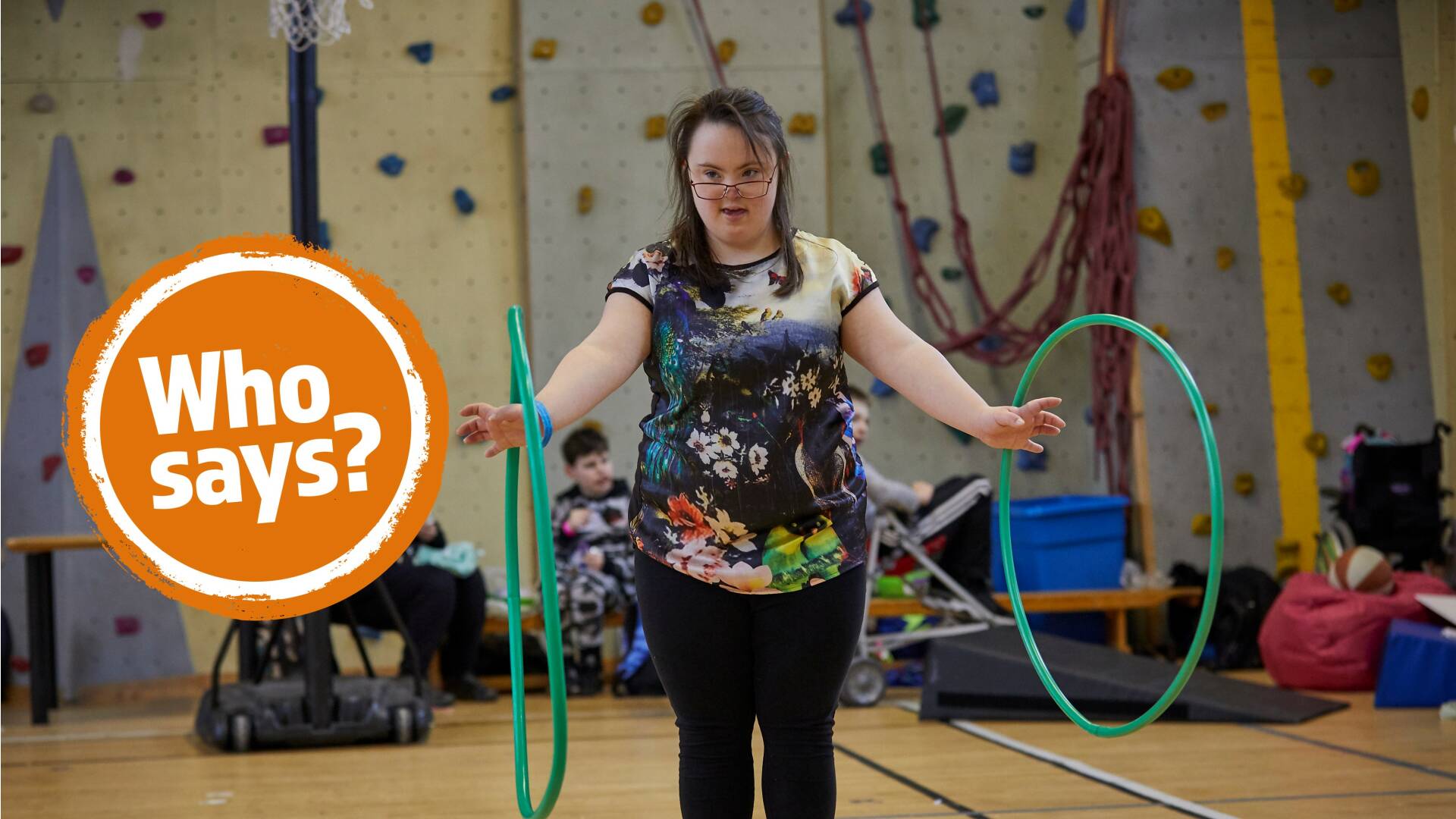 Girl with Down's syndrome playing with two green hula hoops 